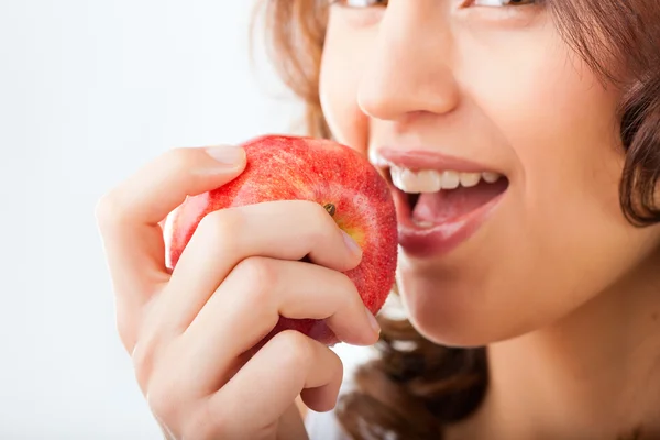 Ung kvinna biter i en apple — Stockfoto