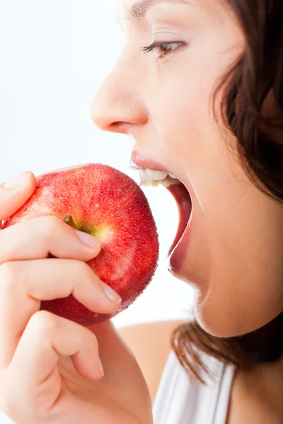 Genç kadın ısırıkları içinde bir elma — Stok fotoğraf