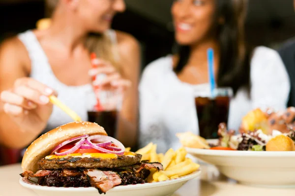 ハンバーガーを食べるとソーダを飲む女性 — ストック写真