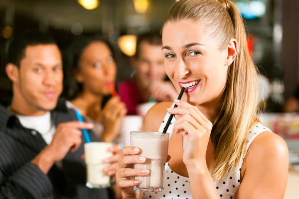 Vänner dricker milkshake i en bar — Stockfoto