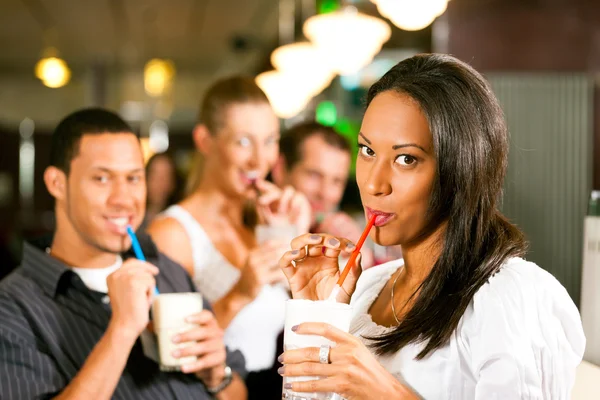 Vrienden milkshakes drinken in een bar — Stockfoto