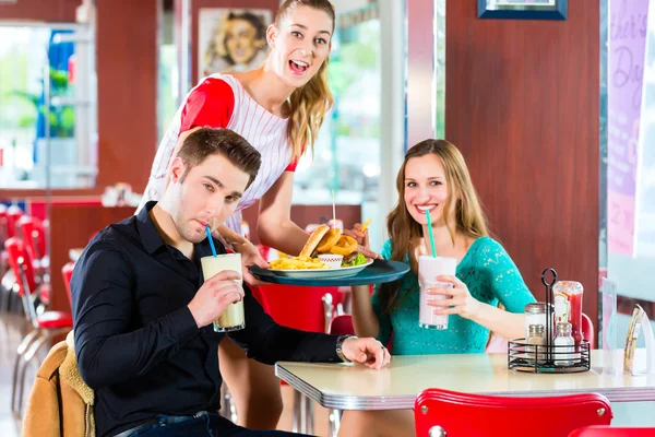Άνθρωποι στο αμερικανικό diner τρώει fast food — Φωτογραφία Αρχείου