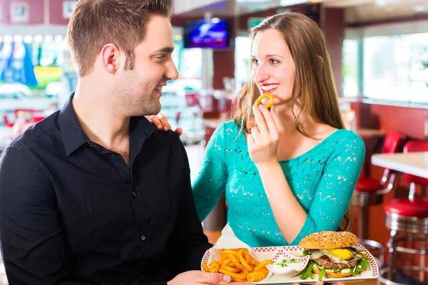 Ζευγάρι να τρώει fast food με burger και τα τηγανητά — Φωτογραφία Αρχείου