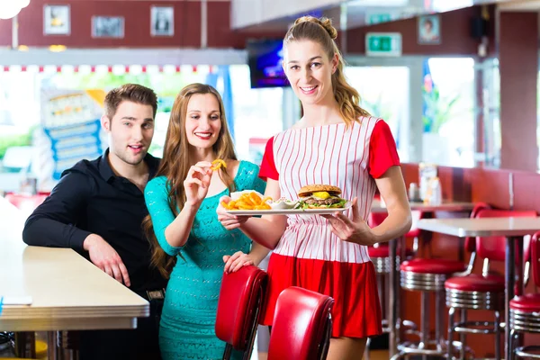 Människor i amerikansk diner eller restaurang och servitris — Stockfoto