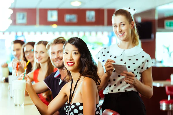 Les gens dans le restaurant américain avec milk shakes — Photo