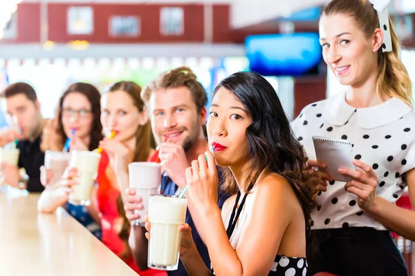 Pessoas no restaurante americano com batidos de leite — Fotografia de Stock