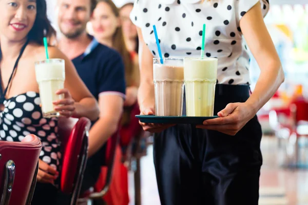 Les gens dans le restaurant américain avec milk shakes — Photo