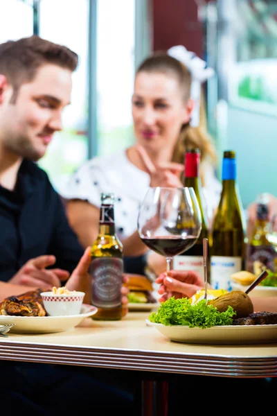 Amigos comiendo y bebiendo en el restaurante de comida rápida — Foto de Stock