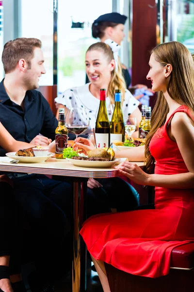 Amigos comiendo y bebiendo en el restaurante de comida rápida —  Fotos de Stock