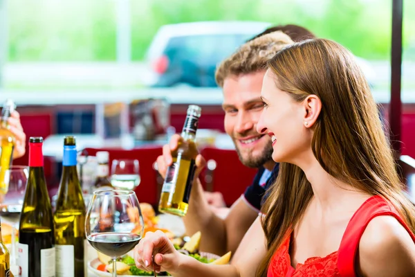 Amigos comiendo y bebiendo en el restaurante de comida rápida — Foto de Stock