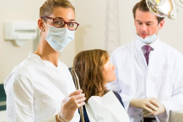 Dentist in his surgery, she holds a drill — Stock Photo, Image