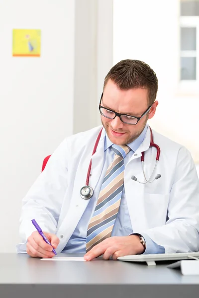 Young doctor writing medical prescription — Stock Photo, Image