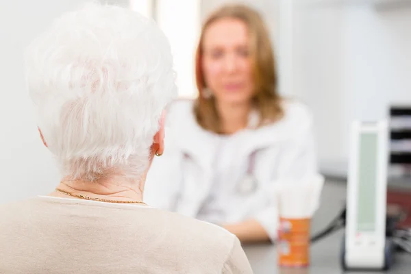 Arzt sieht Seniorin in der Praxis — Stockfoto