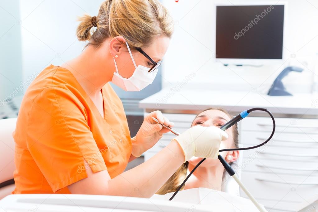 Patient having dental tooth cleaning at dentist Stock Photo by ©Kzenon