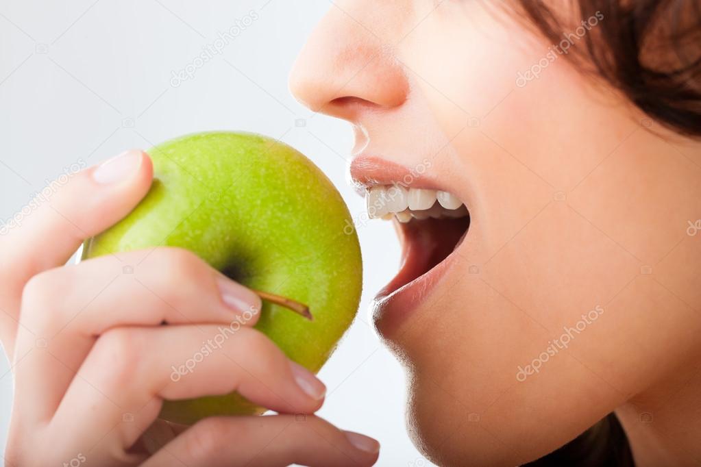 woman bites in a fresh and healthy apple