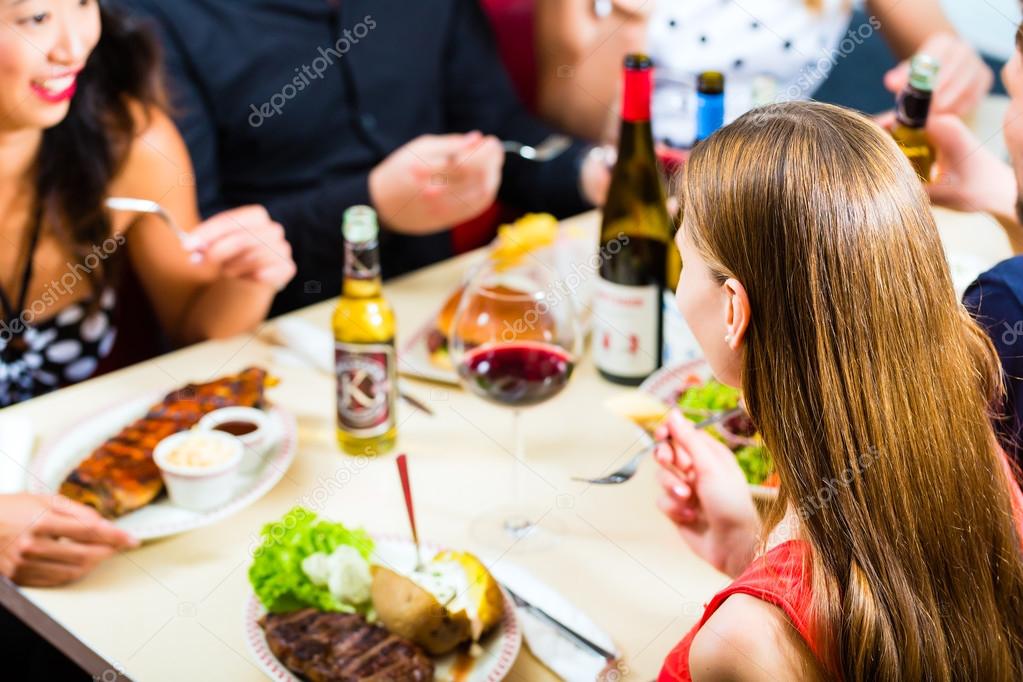 Friends eating and drinking in fast food diner — Stock Photo © Kzenon 79388020