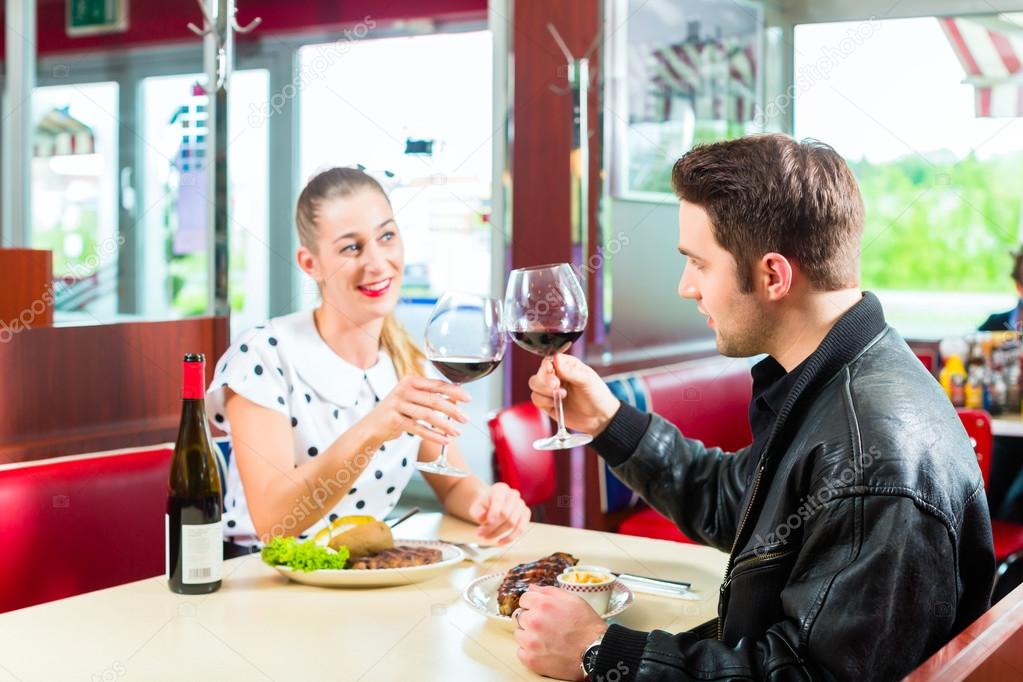 couple eating and drinking in fast food diner