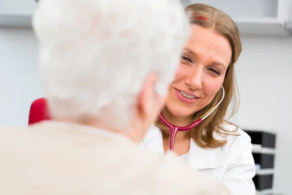 Az orvos méri az idős betegek vérnyomását — Stock Fotó