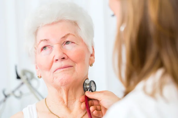 Arzt betäubt Seniorin in Praxis — Stockfoto