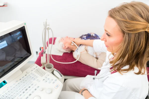 Médico examinando paciente sênior com ultra-som — Fotografia de Stock