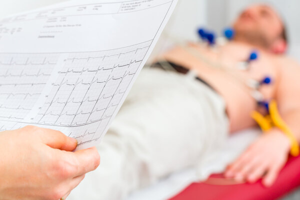 Doktor kontrolliert Patient EKG in Arztpraxis