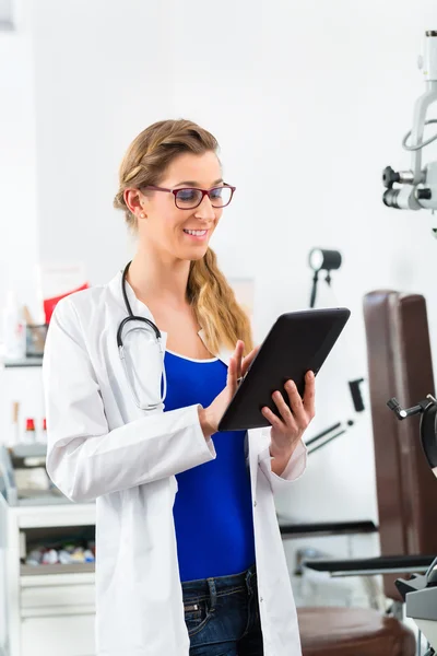 Doctor in de kliniek lezen van digitale bestand op tablet pc — Stockfoto