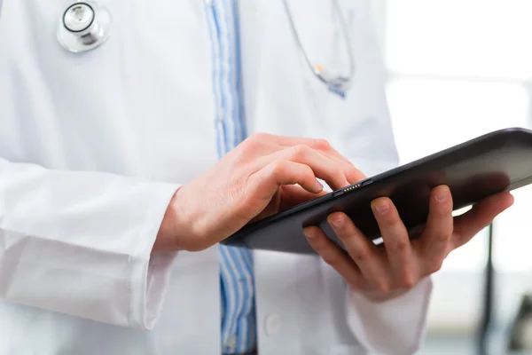 Доктор в клініці читає цифровий файл на планшетному комп'ютері — стокове фото
