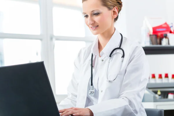 Doctora escribiendo en PC en su clínica — Foto de Stock