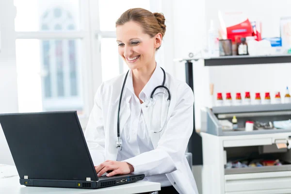 Kobieta lekarz pisanie na komputerze w jej klinice — Zdjęcie stockowe