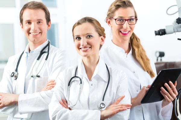 Equipe de médicos na clínica com computador tablet — Fotografia de Stock