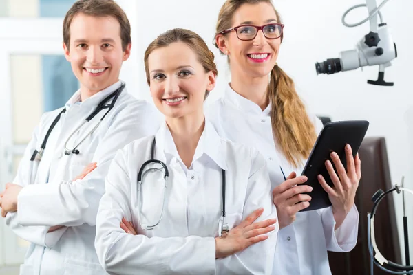 Team med läkare i klinik med tablet PC — Stockfoto