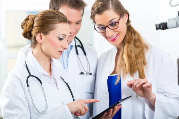 Equipe de médicos na clínica com computador tablet — Fotografia de Stock