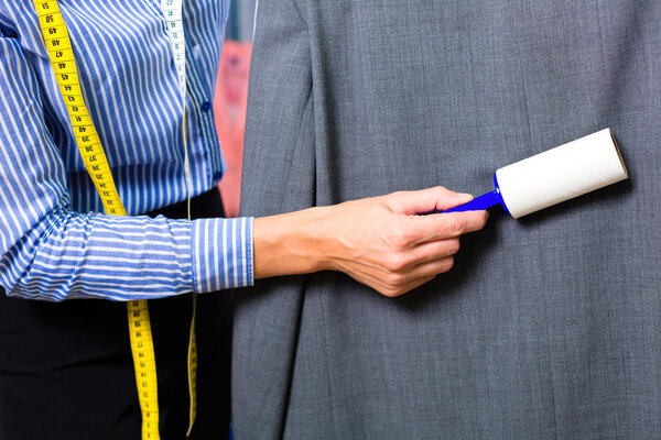 Cleaner in laundry shop checking clean clothes
