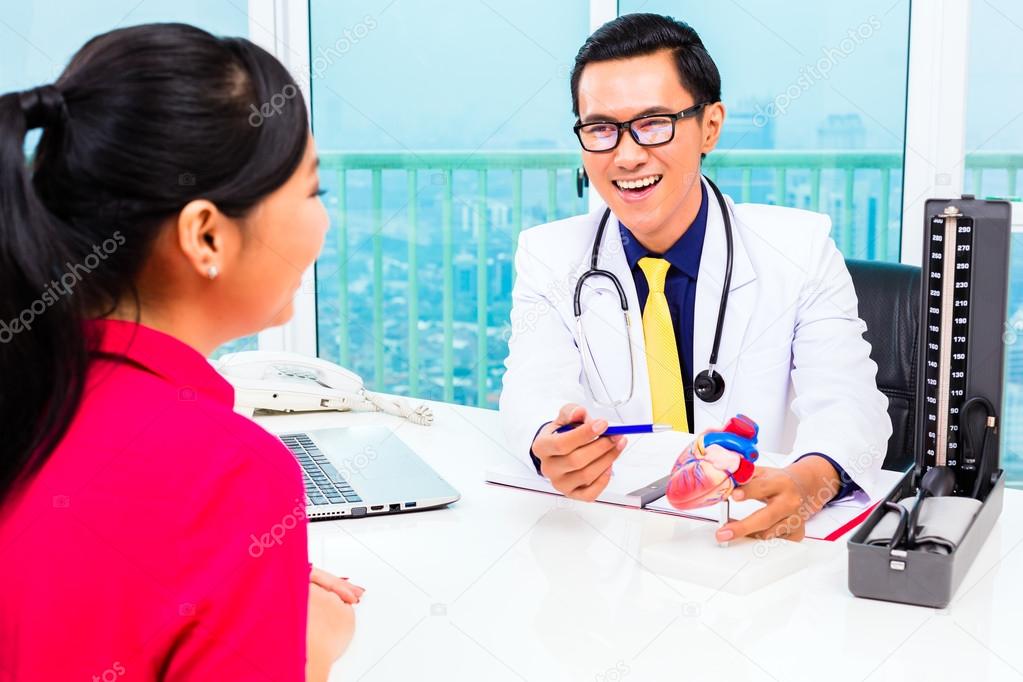 Asian doctor with patient in medical surgery