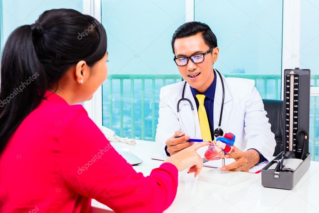 Asian doctor with patient in medical surgery
