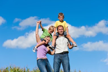 Bir çayır üzerinde çocuklu aile