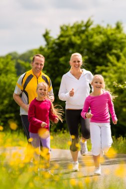 Aile çocukları ile açık havada spor yaz gününde koşu