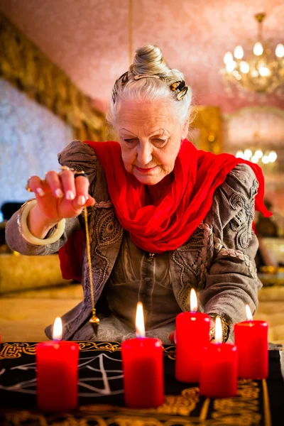 Soothsayer during a Seance or session with pendulum — Stock Fotó
