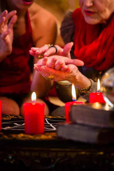 Soothsayer under sessionen gör palmistry — Stockfoto