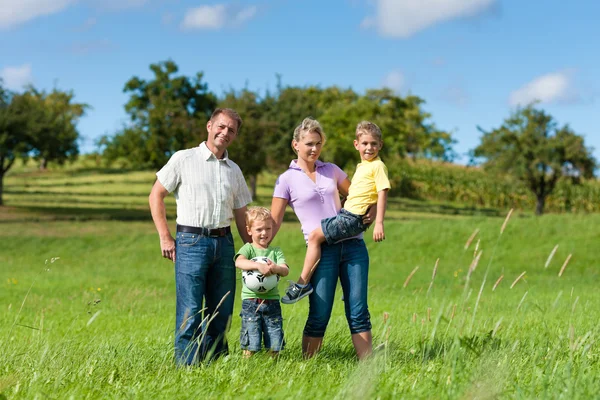 Família com crianças e futebol em um prado — Fotografia de Stock