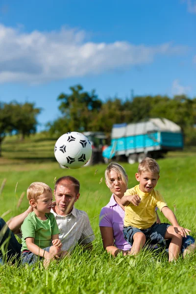 Família com crianças e futebol em um prado — Fotografia de Stock