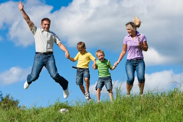 Familia al aire libre saltando — Foto de Stock