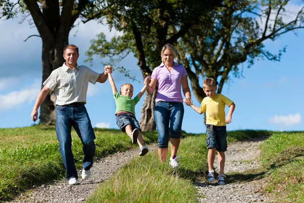 Family outdoors is running on a dirt path — Stock Photo, Image