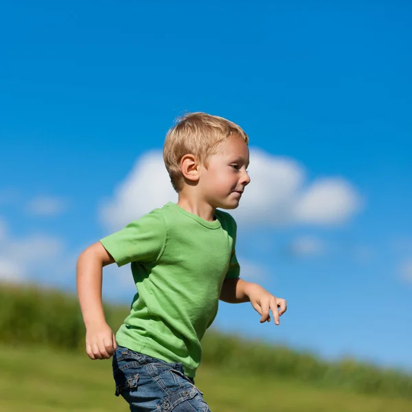 Boy running down a meadow — Stock Photo, Image