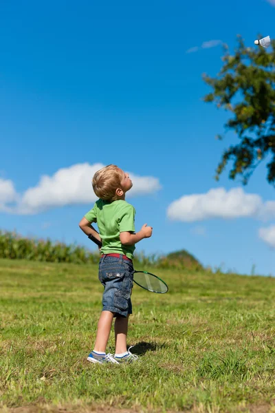 Familj - liten pojke spelar badminton utomhus — Stockfoto