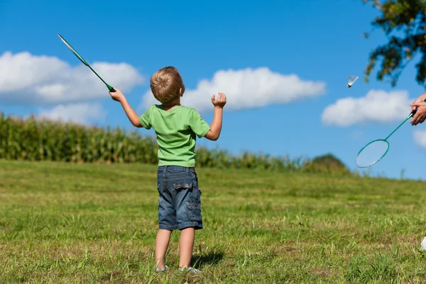 Сім'я маленький хлопчик грає в бадмінтон на відкритому повітрі — стокове фото