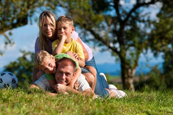 Famille avec enfants et football sur une prairie — Photo