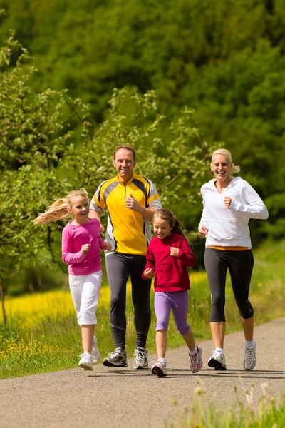 Familia corriendo en el prado para el deporte — Foto de Stock