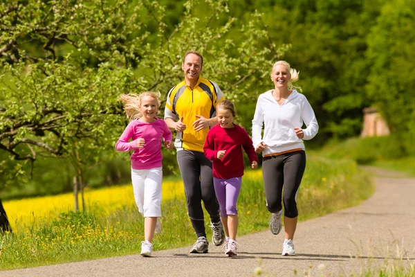 Courir en famille dans la prairie pour le sport — Photo