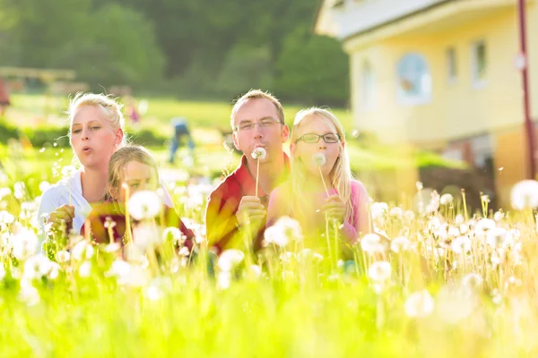 Famiglia seduta nel prato di fronte a casa — Foto Stock